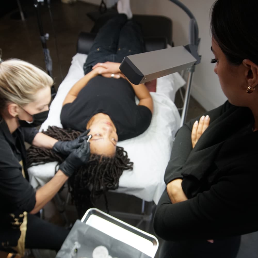 Rojin of Rouge Ink supervises a student performing a service.