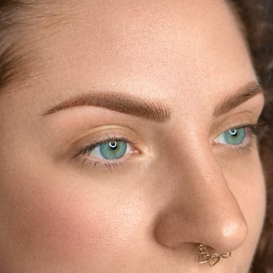 Close-up of natural combo brows on female with green eyes