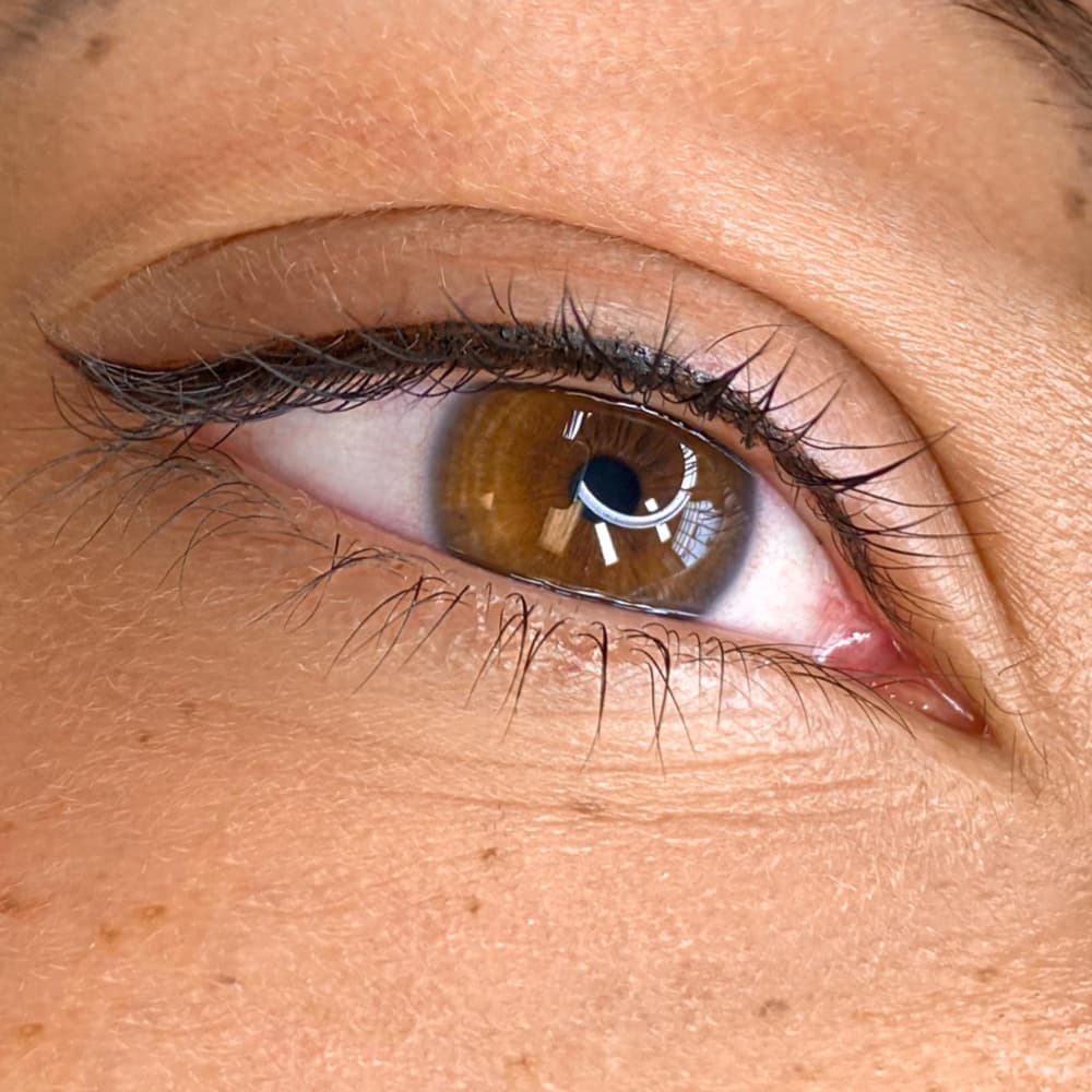 Close-up of semi-permanent eyeliner tattooing at Rouge Ink, creating fuller lashes and enhanced eye definition.