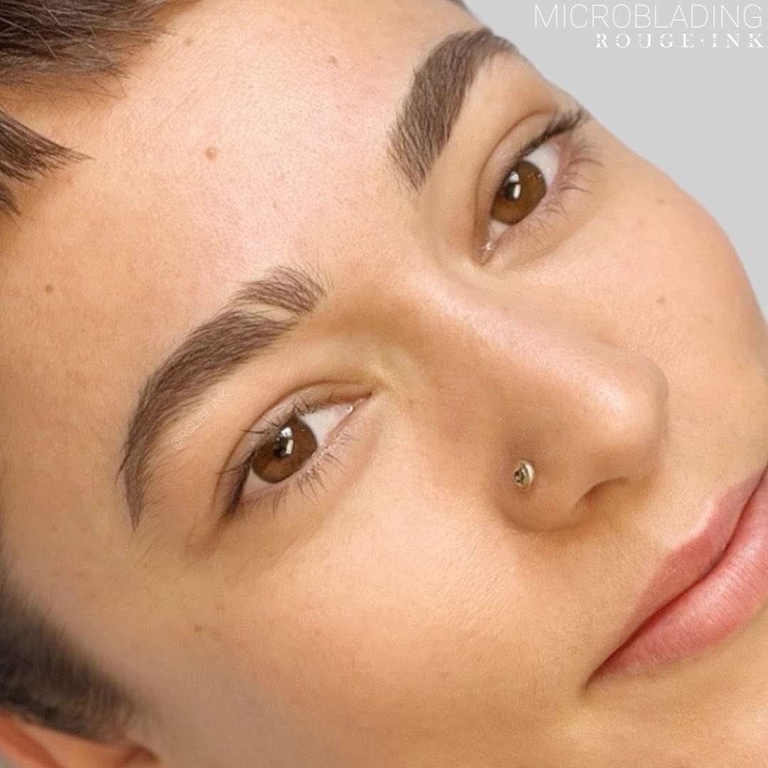 Up-close of a female client with microbladed brows at Rouge Ink.